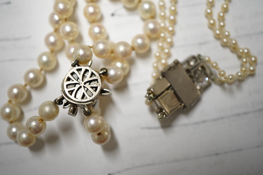 Two double strand cultured pearl necklaces, one graduated with paste set white metal clasp, 48cm, the other with cultured pearl set 9ct white gold clasp.